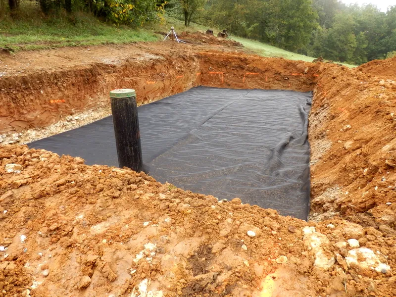 Excavator exposing a septic drain field on an Alaska property