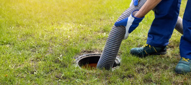 A technician pumping out a residential septic tank